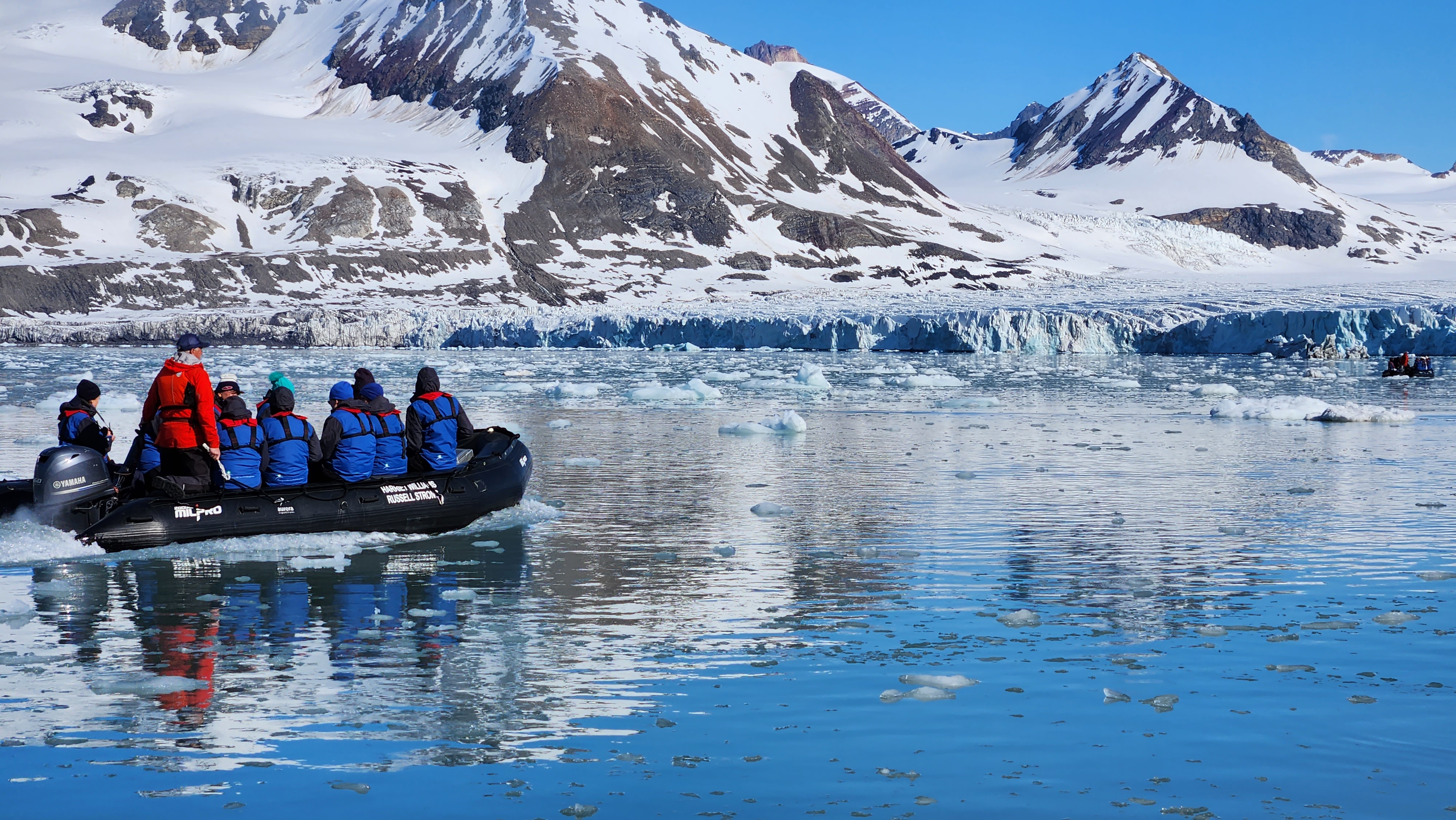 Zodiac expedition boat beside a glacier in Svalbard
