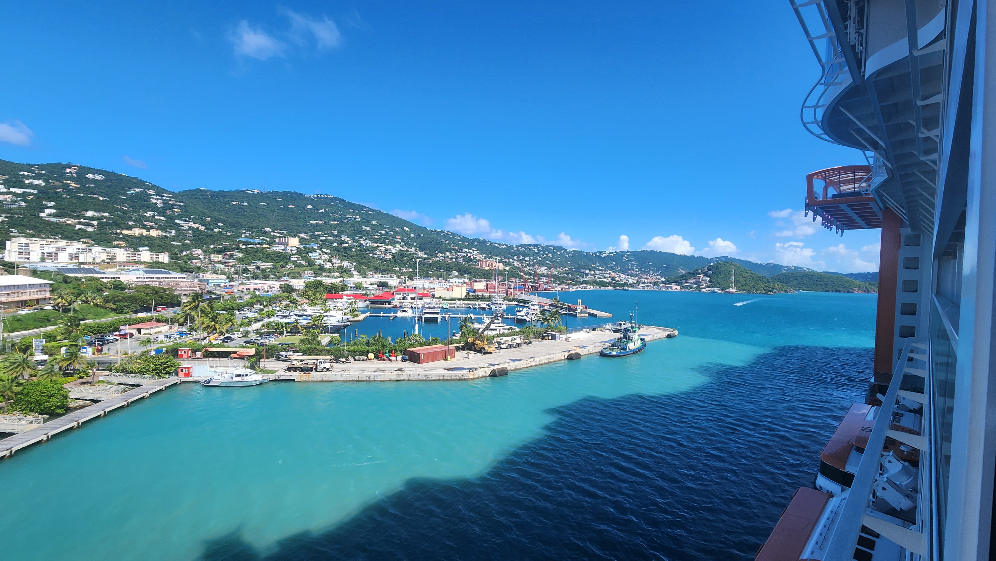 Turquoise Caribbean harbor surrounded by green island hills