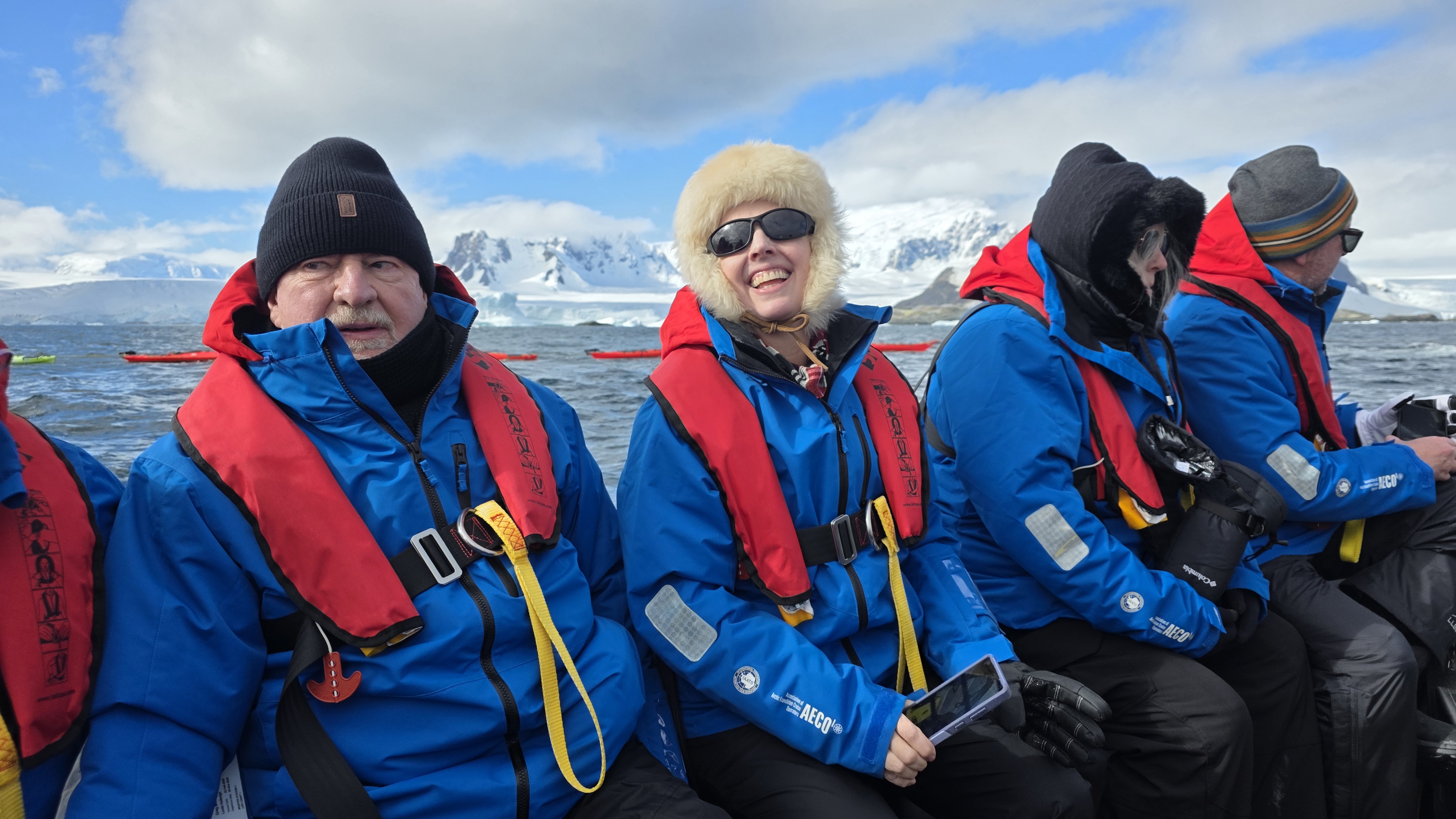 Expedition cruise guests riding together in a Zodiac in Antarctica.