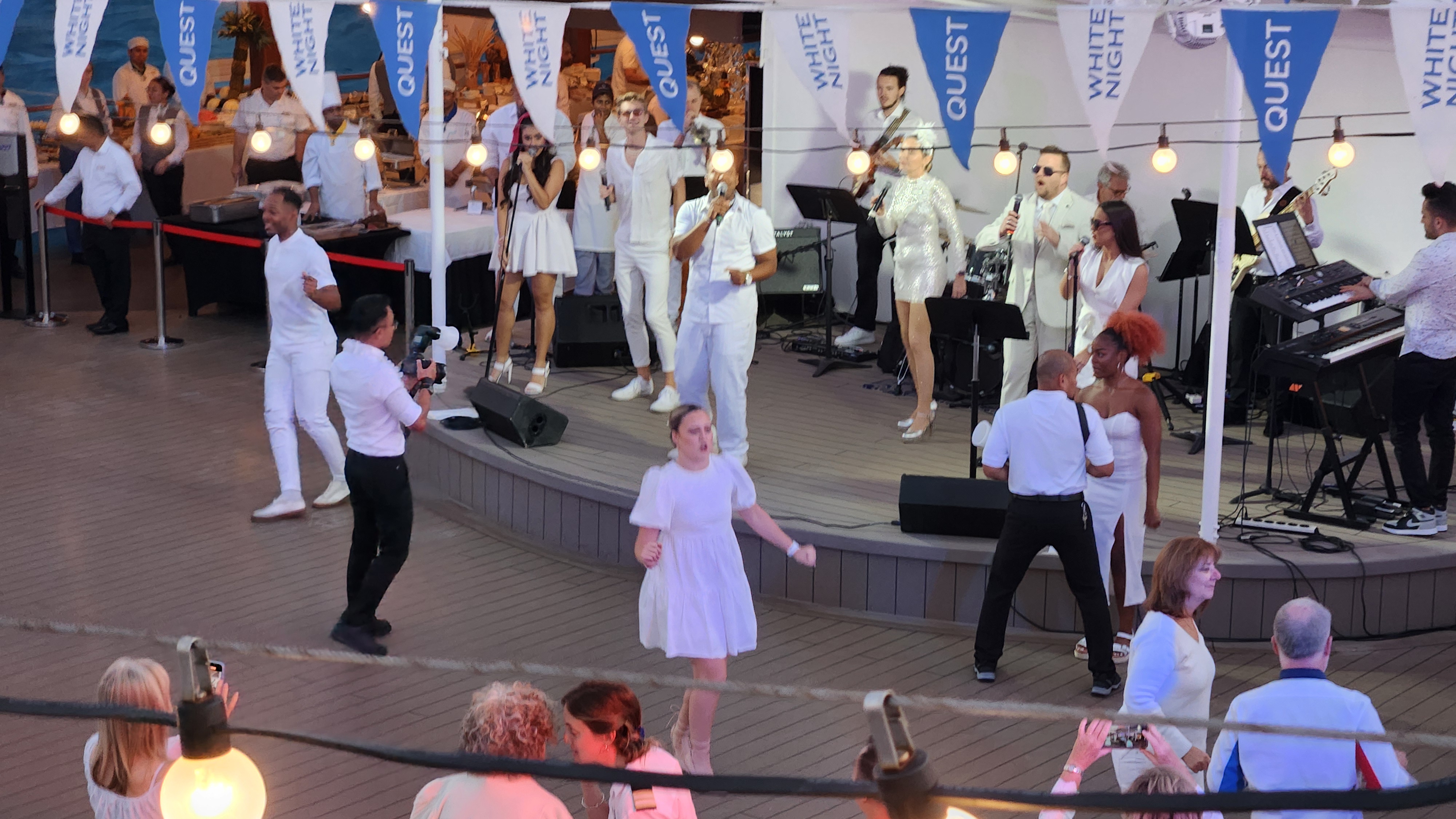 Guests dining and socializing during an Azamara White Night onboard event.