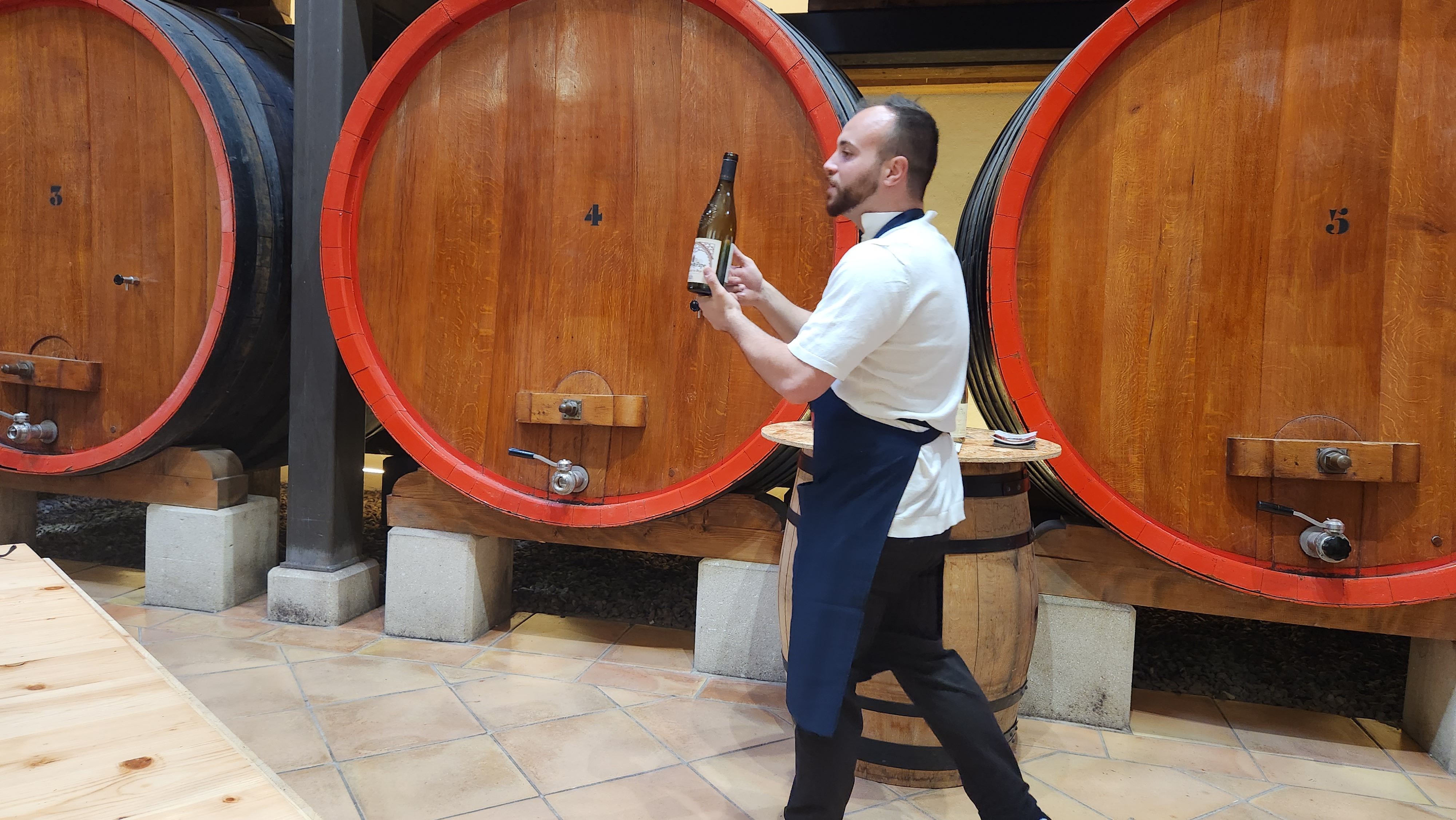 Wine cellar in Provence with large wooden vats and a bottle presentation.
